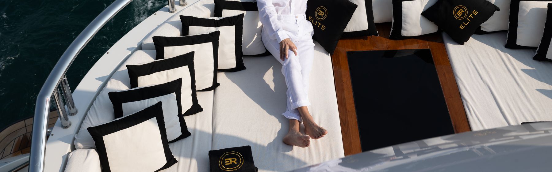 Branded deck cushions on the bow of a charter yacht