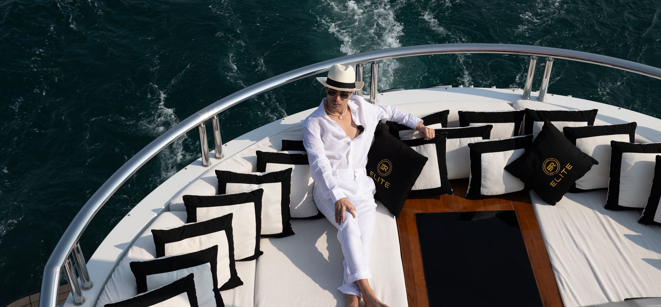 Guest relaxing on the bow of a crewed charter yacht underway