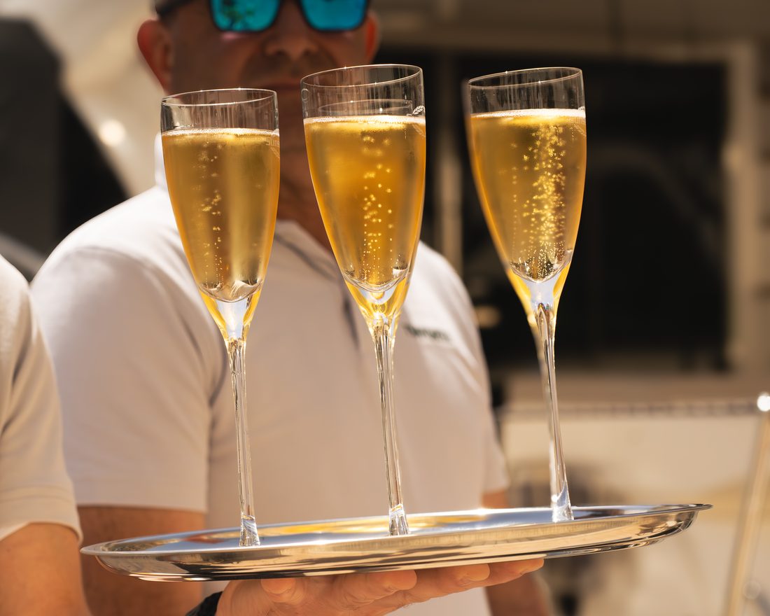 Crew serving welcome champagne on a silver tray